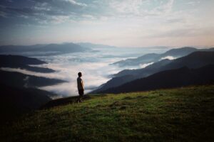 hiker on the mountain above a valley hidden in fog